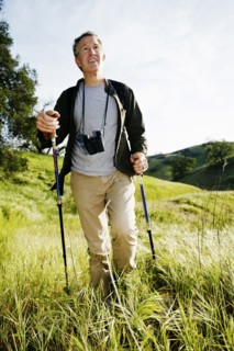 Caucasian man hiking in grass on mountain