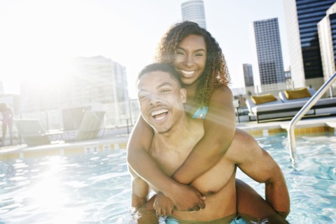 Smiling couple enjoying urban swimming pool