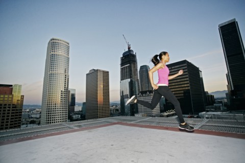 Mixed Race woman running on urban rooftop