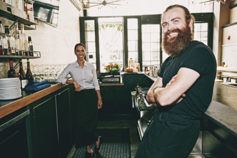 Smiling bartenders relaxing behind bar