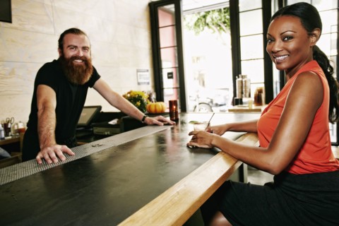 Smiling bartender and customer at bar