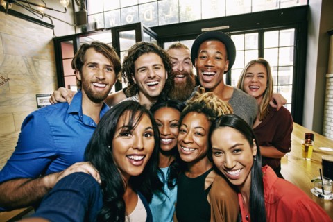 Smiling friends posing in bar