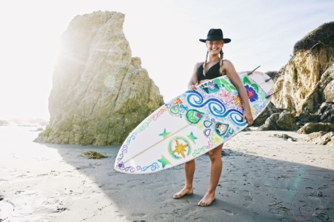 Caucasian woman carrying surfboard at beach