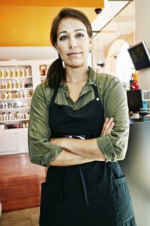 Serious Mixed Race hairdresser posing in hair salon