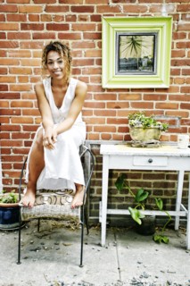 Smiling Mixed Race sitting on top of chair in garden