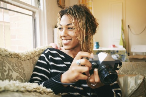Smiling Mixed Race woman holding camera
