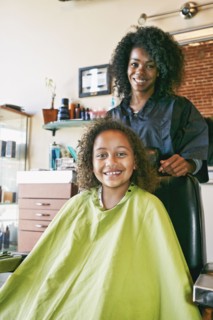Smiling hairdresser and customer in hair salon