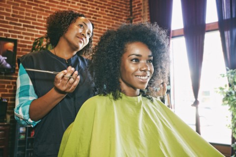 Smiling hairdresser and customer in hair salon
