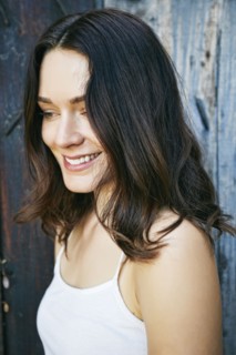 Smiling Caucasian woman near wooden fence