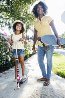 Mother and daughter posing on sidewalk