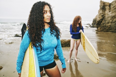 Serious women holding surfboards at beach