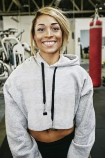 Smiling Mixed Race woman posing in gymnasium