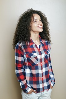 Hispanic woman with hands in pockets looking up