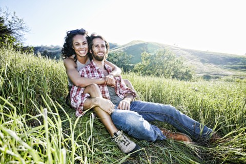 Portrait of smiling couple hugging on hill