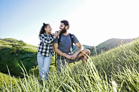 Father and daughter smiling on hill