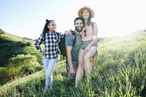 Portrait of smiling family posing on hill