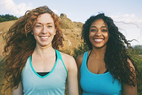 Women standing near boulder in wind