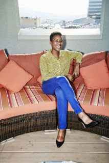 Black woman sitting on rooftop sofa