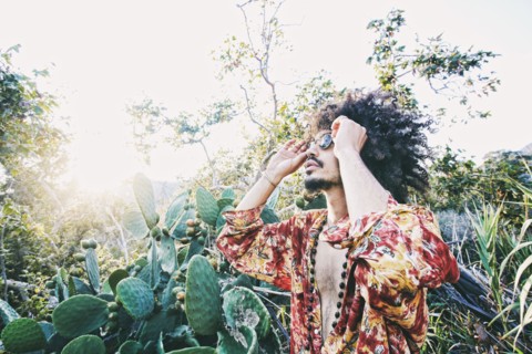 Mixed Race man wearing sunglasses near cactus
