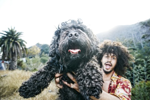 Mixed Race man holding shaggy dog