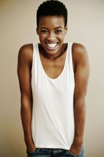 Portrait of smiling Black woman with hands in pockets