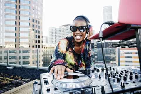 Smiling Black DJ on urban rooftop