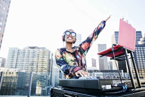 Smiling Black DJ on urban rooftop