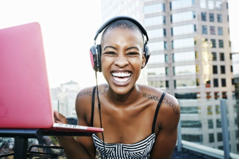 Portrait of Black DJ laughing on urban rooftop