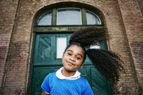 Smiling Black girl tossing hair