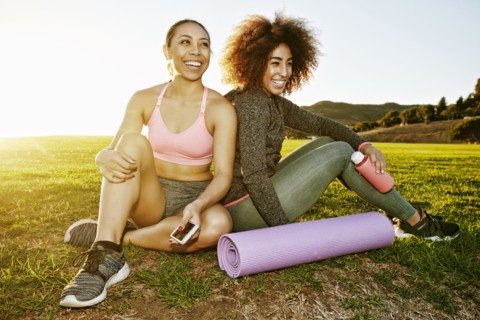 Smiling women sitting in sunny field