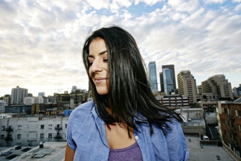 Portrait of smiling Hispanic woman on urban rooftop