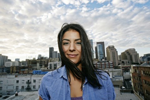 Portrait of smiling Hispanic woman on urban rooftop
