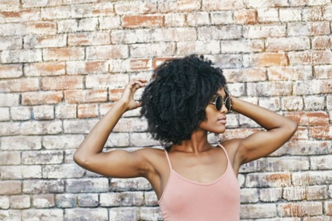 Serious Black woman near brick wall