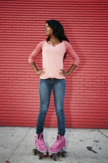 Black woman wearing roller skates on sidewalk
