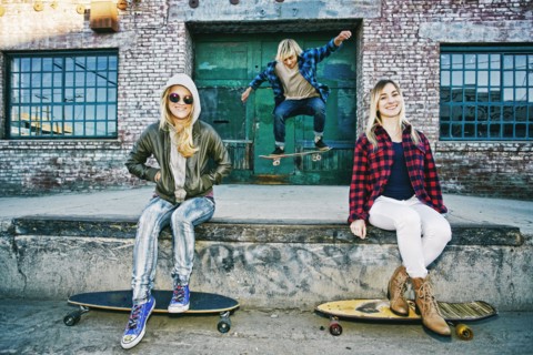 Friends with skateboards smiling on loading dock