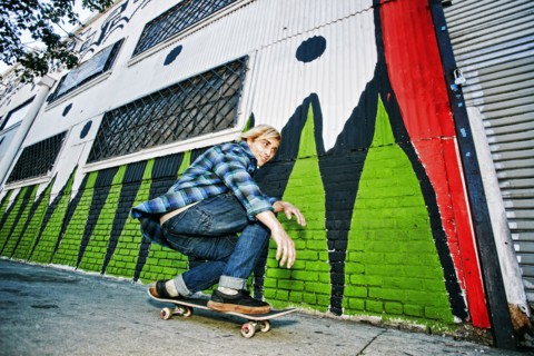 Caucasian man skateboarding on urban sidewalk