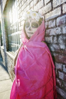 Mixed Race woman wearing scarf and skull face paint