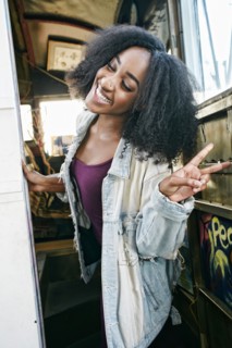Mixed race woman gesturing peace sign on bus