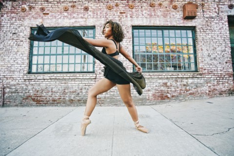 Mixed race woman dancing ballet on sidewalk