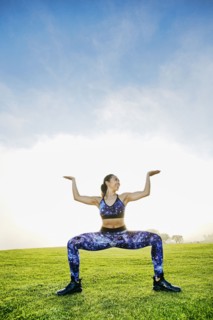Mixed race woman squatting in field