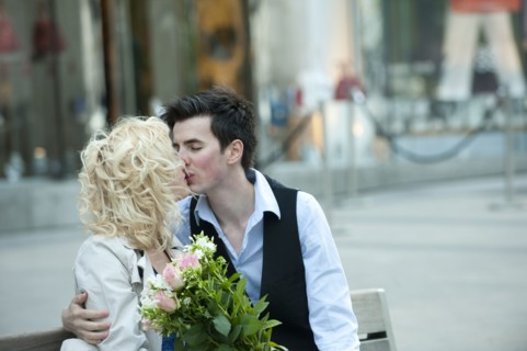Caucasian couple kissing on bench