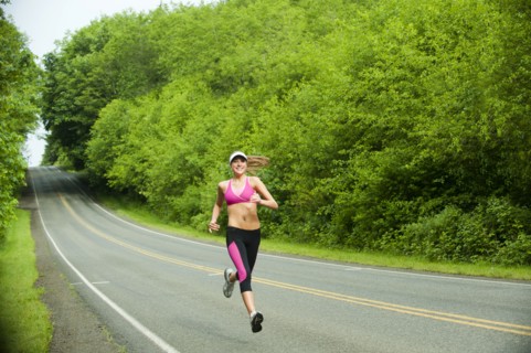 Caucasian woman running on remote road