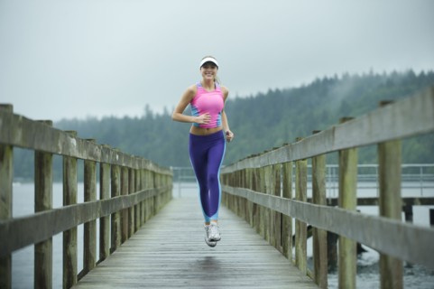 Caucasian woman running on pier