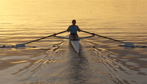 Person rowing sculling boat on river