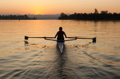 Person rowing sculling boat on river