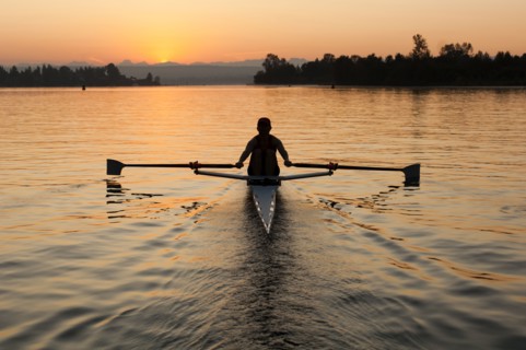 Person rowing sculling boat on river