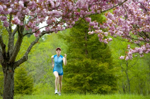 Mixed race runner jogging across grass