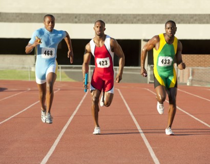 Runners running on track in relay race