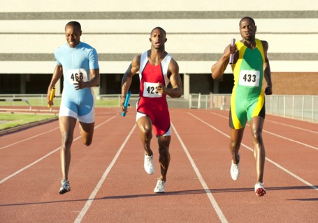 Runners running on track in relay race