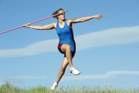 Caucasian athlete throwing javelin